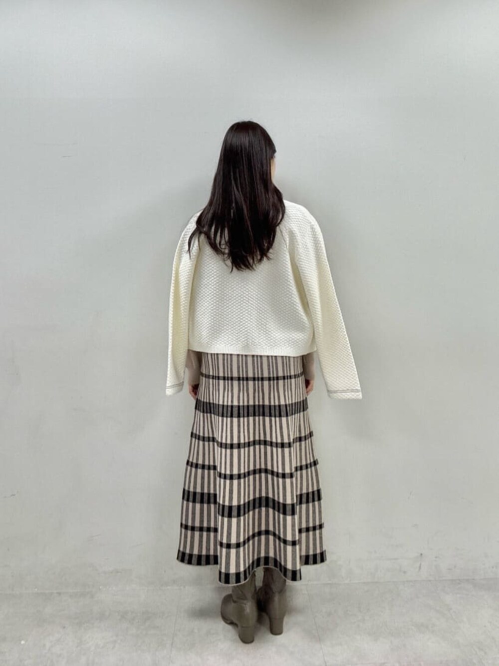 ベージュ系のワンピース、ホワイト系のニット/セーターを着用したレディースの秋コーディネートの4枚目の写真