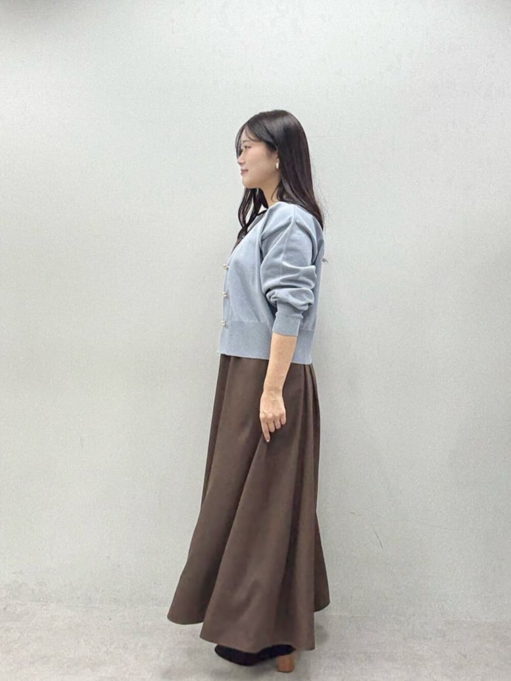 ブラウン系のワンピース、ブルー系のカーディガン/ボレロを着用したレディースの秋コーディネートの2枚目の写真