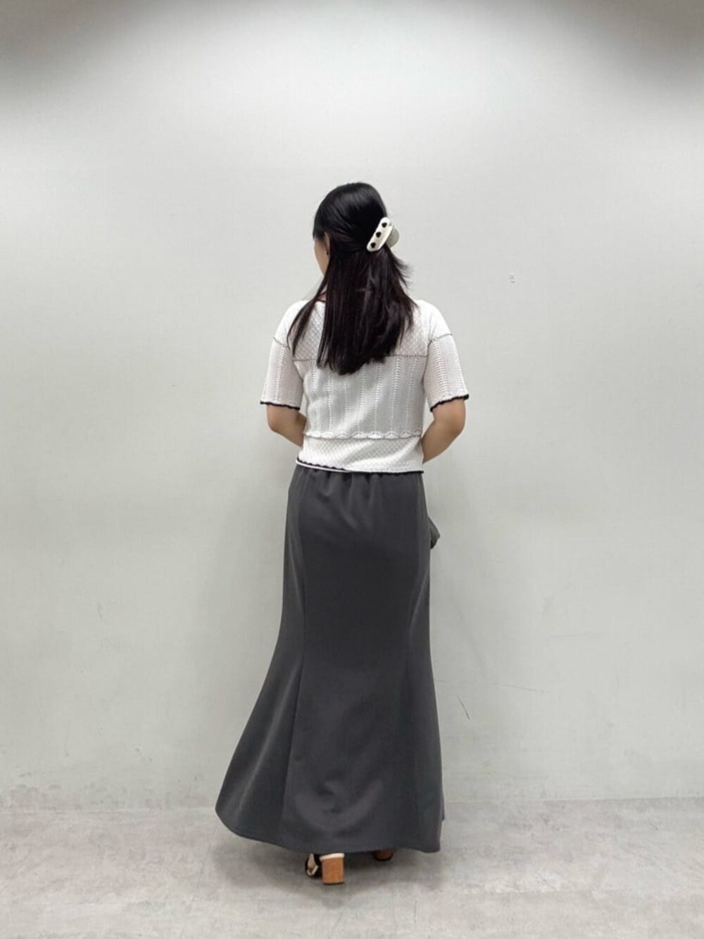 グレー系のスカート、ホワイト系のカーディガン/ボレロを着用したレディースの夏コーディネートの3枚目の写真