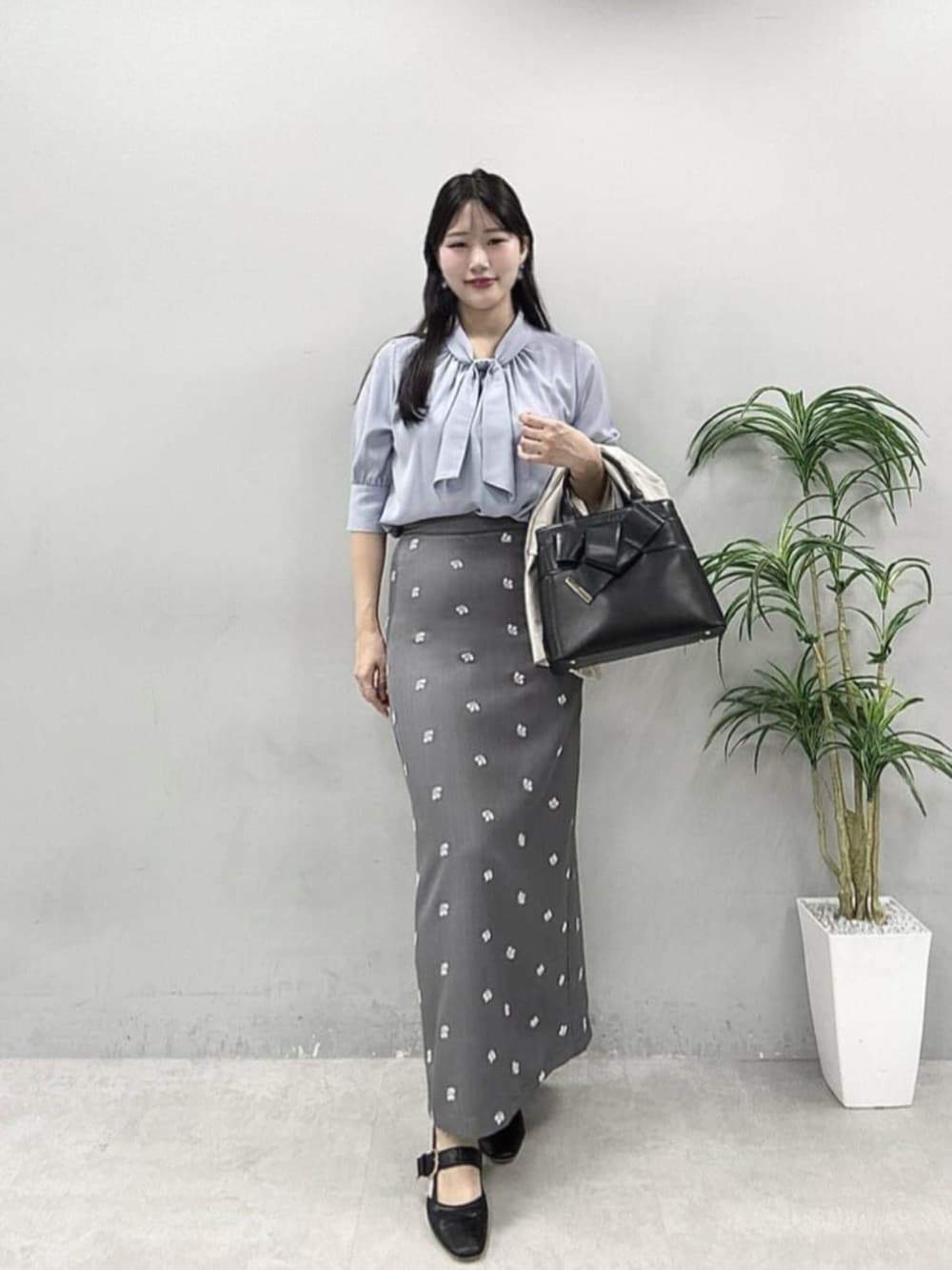 ブルー系のシャツ/ブラウス、ベージュ系のテーラードジャケット、グレー系のスカートを着用したレディースの春コーディネートの2枚目の写真