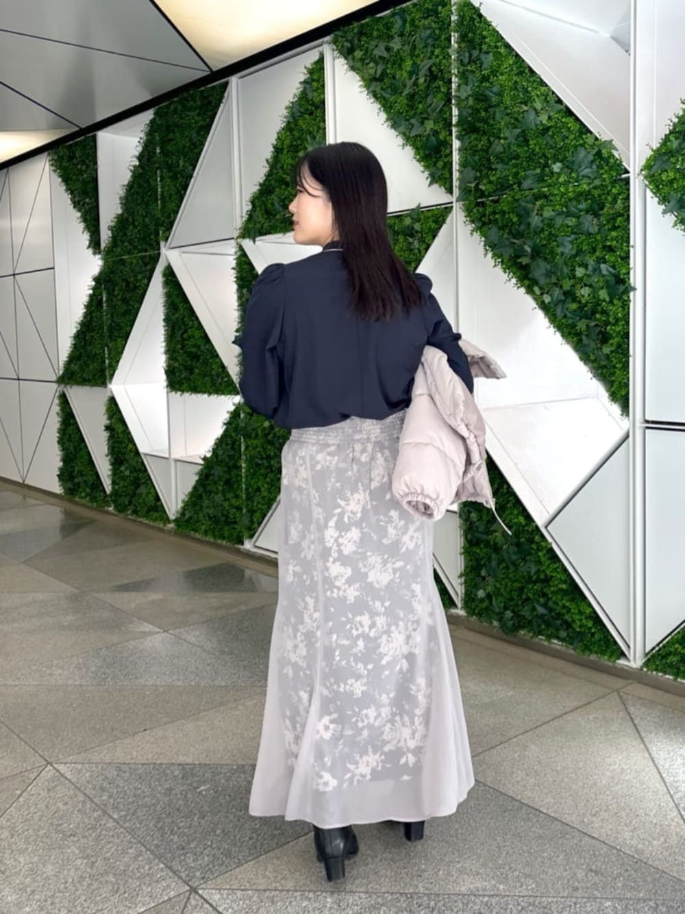 ブラック系のスカート、ベージュ系のダウンジャケット/コート、ブルー系のシャツ/ブラウスを着用したレディースの秋コーディネートの5枚目の写真