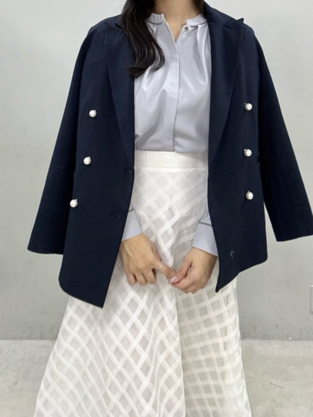 ホワイト系のスカート、ブルー系のシャツ/ブラウス、ブルー系のテーラードジャケットを着用したレディースの冬コーディネートの4枚目の写真