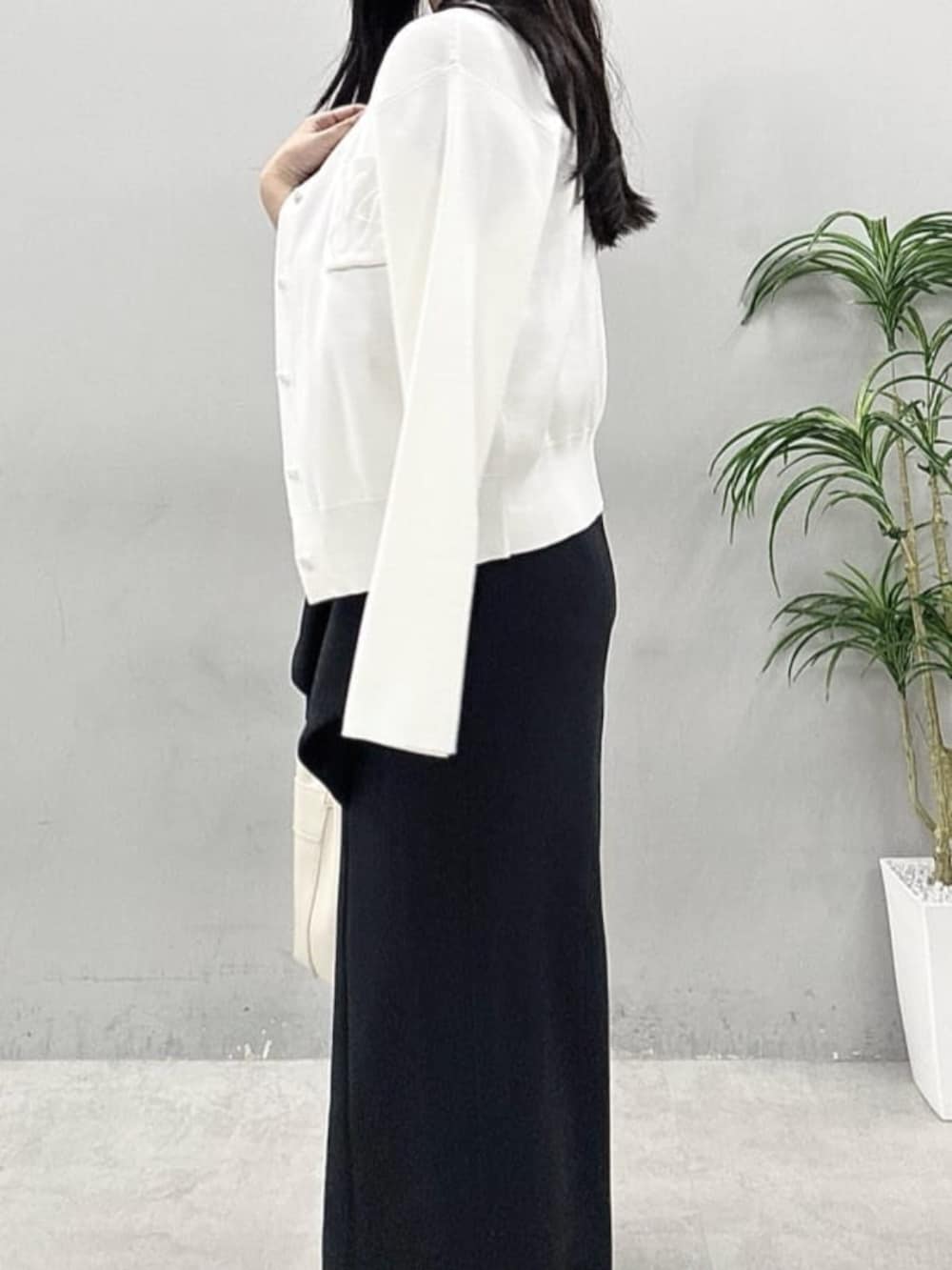 ブラック系のスカート、ホワイト系のカーディガン/ボレロ、ブルー系のシャツ/ブラウスを着用したレディースの春コーディネートの7枚目の写真