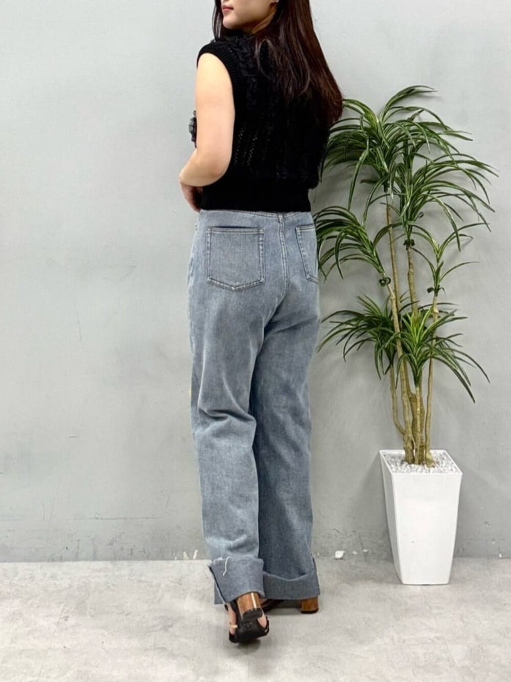 ブラック系のニット/セーター、イエロー系のショルダーバッグを着用したレディースの夏コーディネートの3枚目の写真