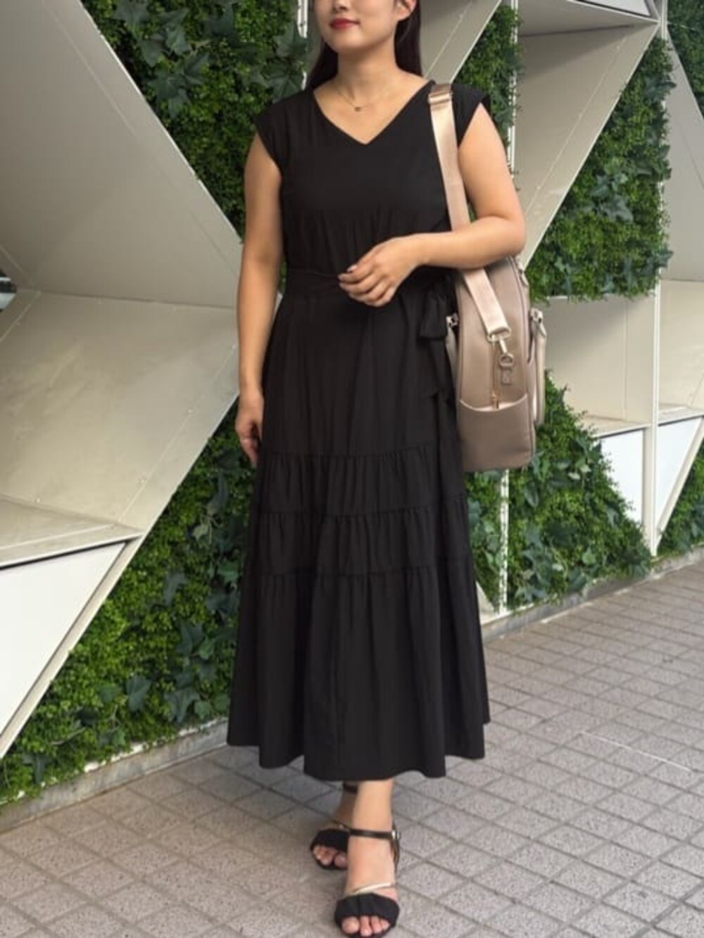 ベージュ系のボストンバッグ、ブラック系のワンピースを着用したレディースの秋コーディネートの2枚目の写真