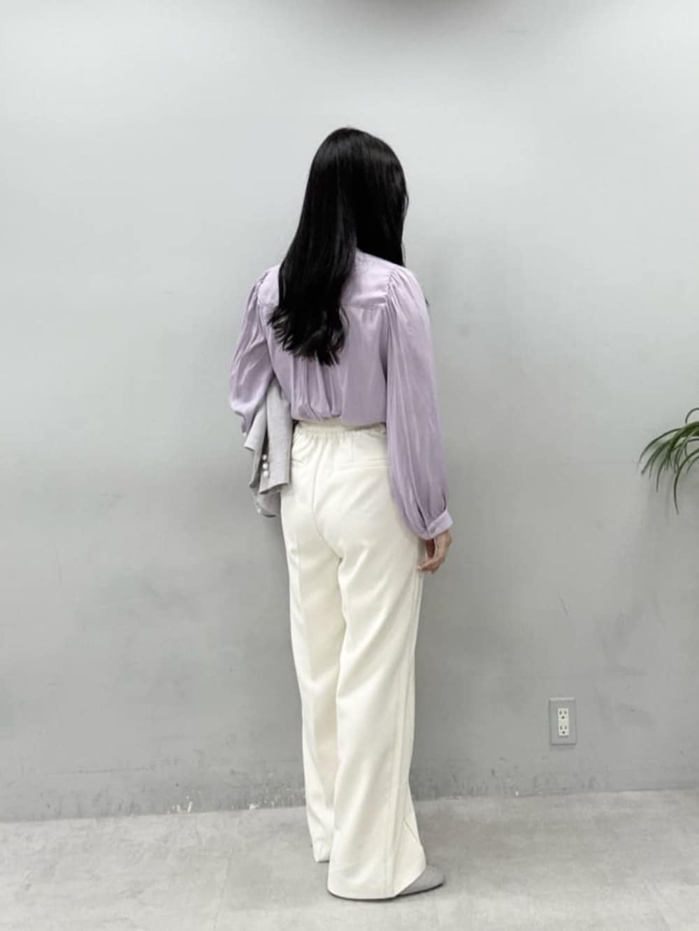 ホワイト系のハンドバッグ、パープル系のシャツ/ブラウス、ホワイト系のスラックスを着用したレディースの冬コーディネートの3枚目の写真