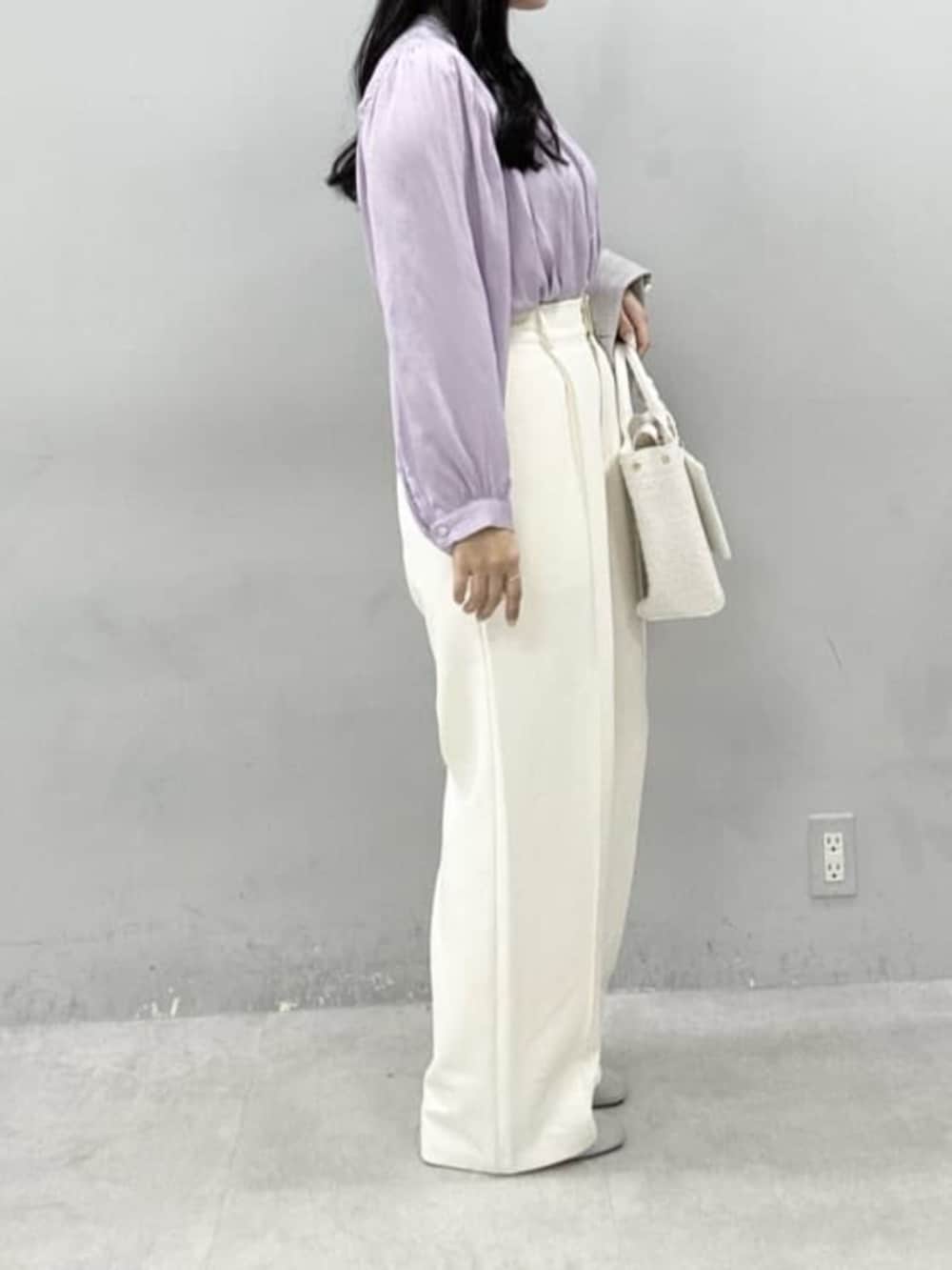 ホワイト系のハンドバッグ、パープル系のシャツ/ブラウス、ホワイト系のスラックスを着用したレディースの冬コーディネートの2枚目の写真