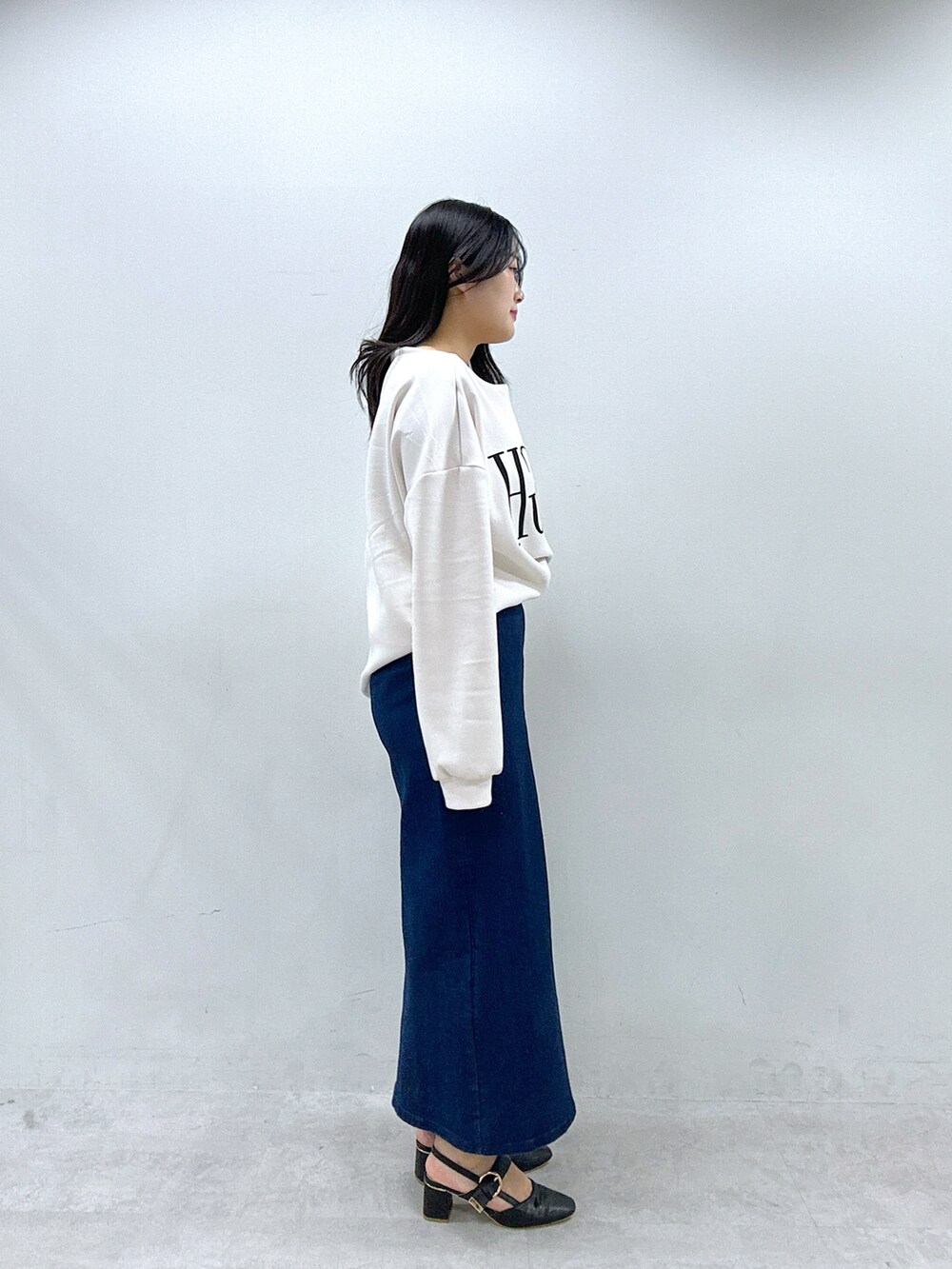 ホワイト系のTシャツ/カットソー、ブルー系のスカート、ブラック系のサンダルを着用したレディースの春コーディネートの2枚目の写真