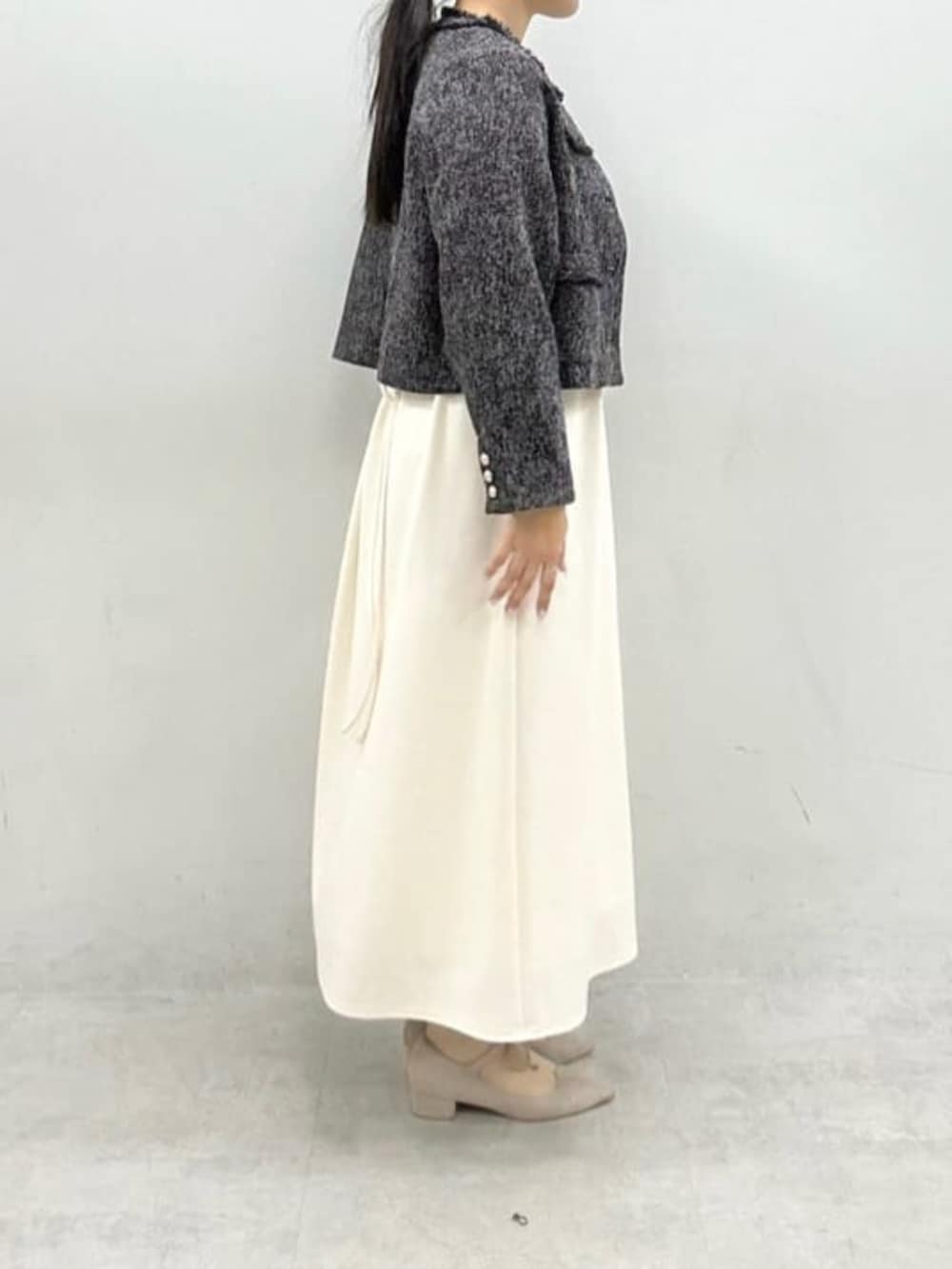 ブラック系のノーカラージャケット、ホワイト系のワンピースを着用したレディースの冬コーディネートの5枚目の写真