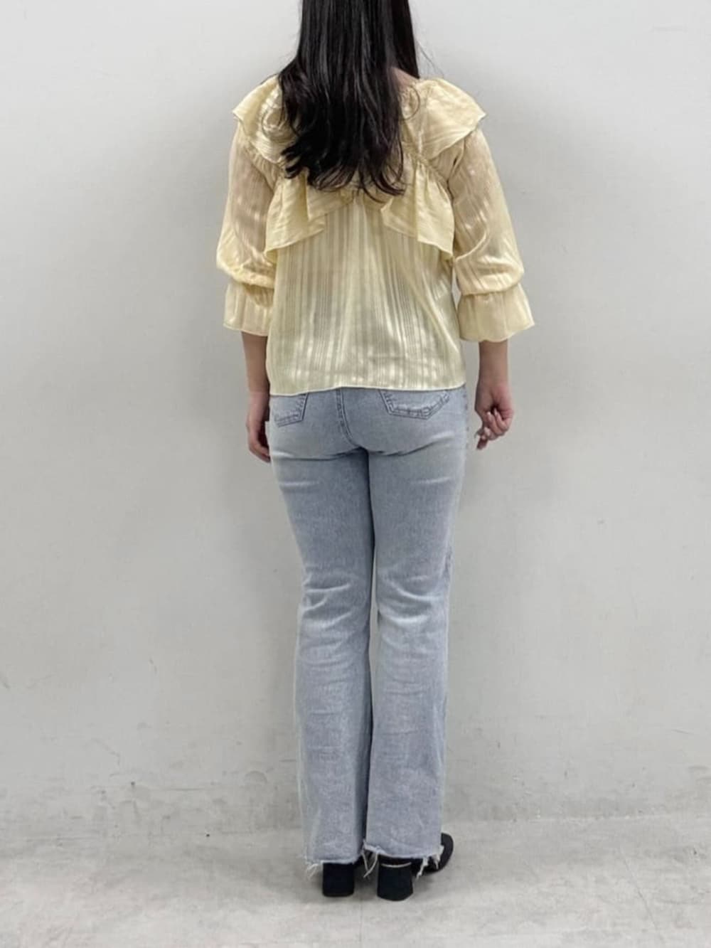 イエロー系のシャツ/ブラウス、ブルー系のデニムパンツを着用したレディースの冬コーディネートの3枚目の写真