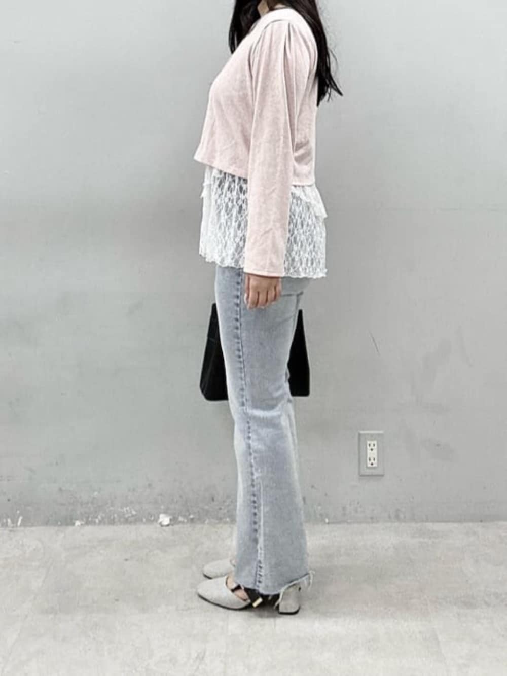 ブルー系のデニムパンツ、ピンク系のカーディガン/ボレロ、ブラック系のショルダーバッグを着用したレディースの春コーディネートの2枚目の写真