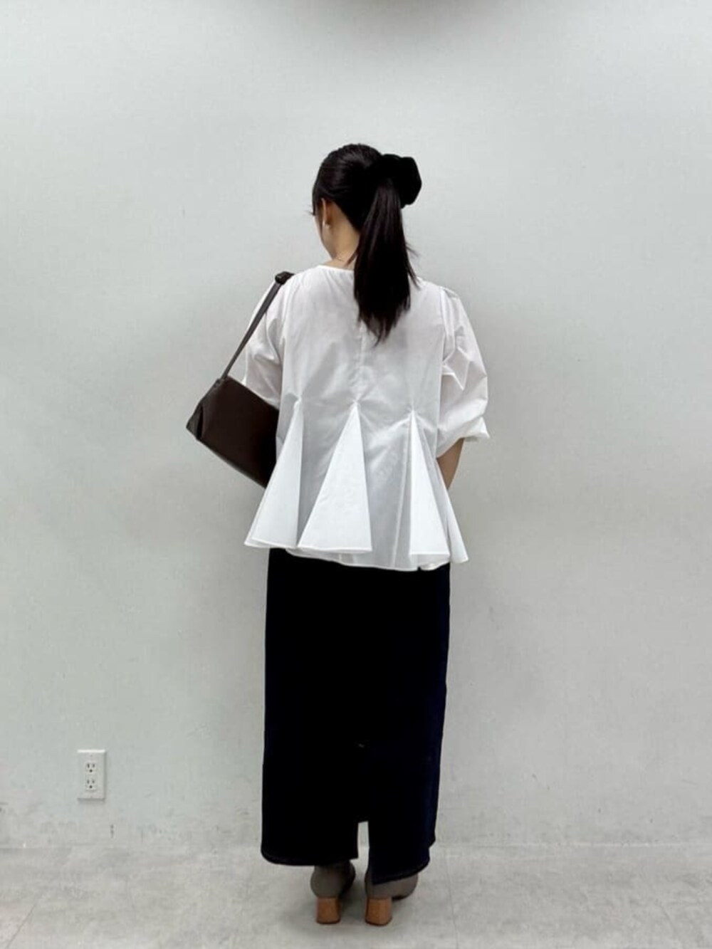 ブルー系のスカート、ホワイト系のシャツ/ブラウスを着用したレディースの秋コーディネートの3枚目の写真