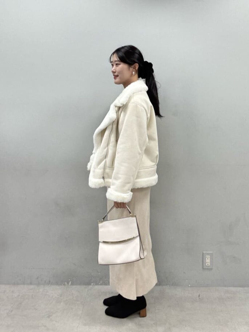 グレー系のシャツ/ブラウス、ベージュ系のスカート、ホワイト系のブルゾンを着用したレディースの秋コーディネートの2枚目の写真