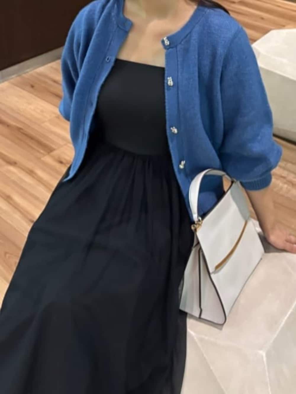 ブラック系のワンピース、ブルー系のカーディガン/ボレロを着用したレディースの秋コーディネートの3枚目の写真