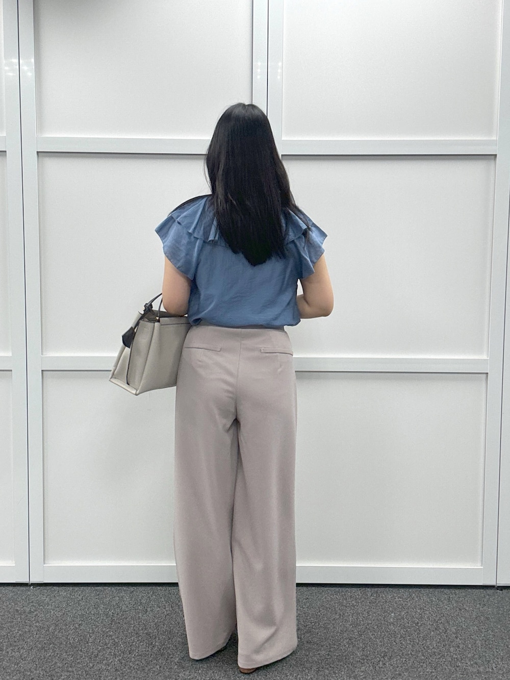 グレー系のショルダーバッグ、ブルー系のシャツ/ブラウス、ベージュ系のその他パンツを着用したレディースの春コーディネートの3枚目の写真