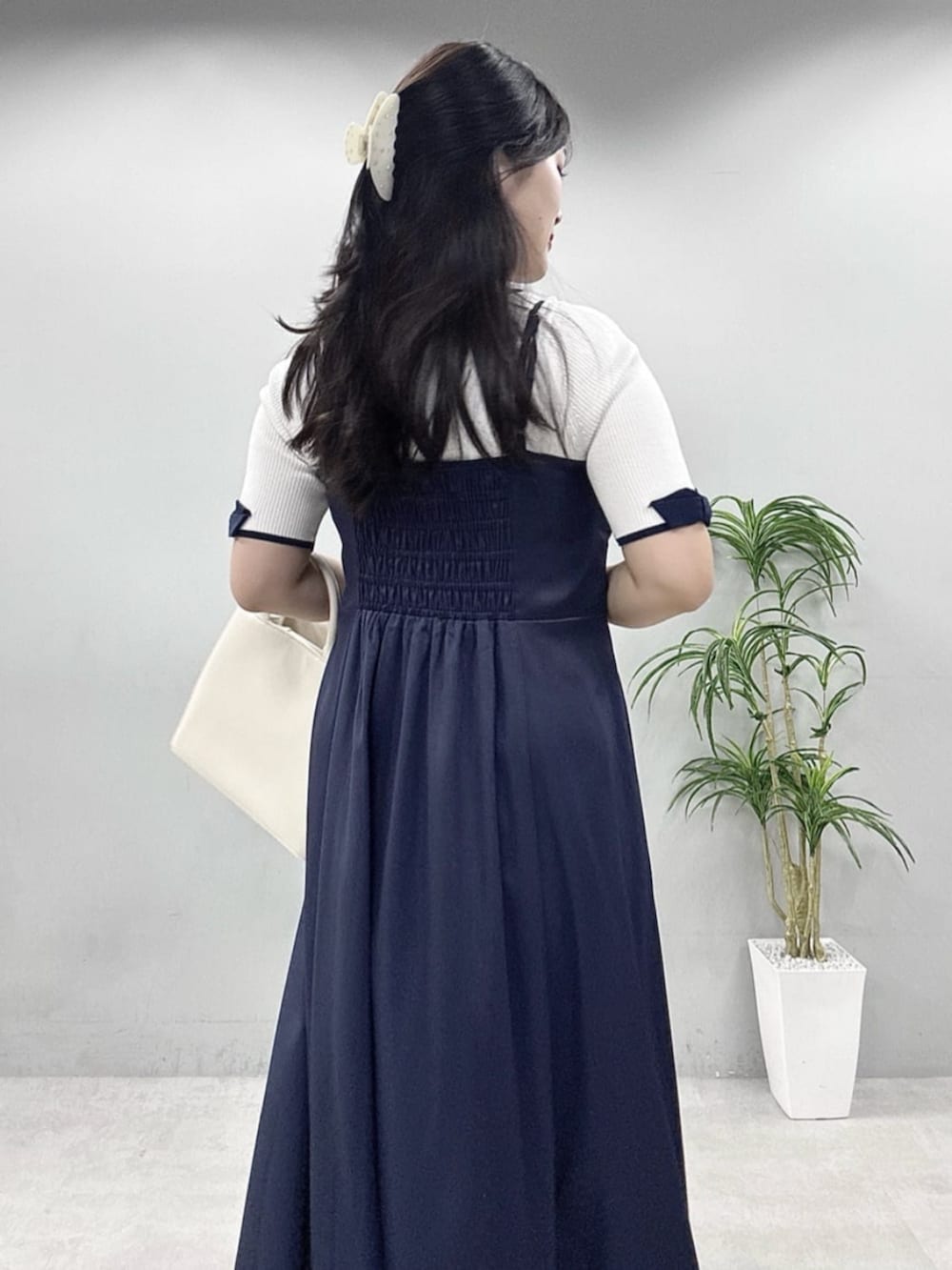 ブルー系のワンピース、ホワイト系のニット/セーターを着用したレディースの春コーディネートの6枚目の写真