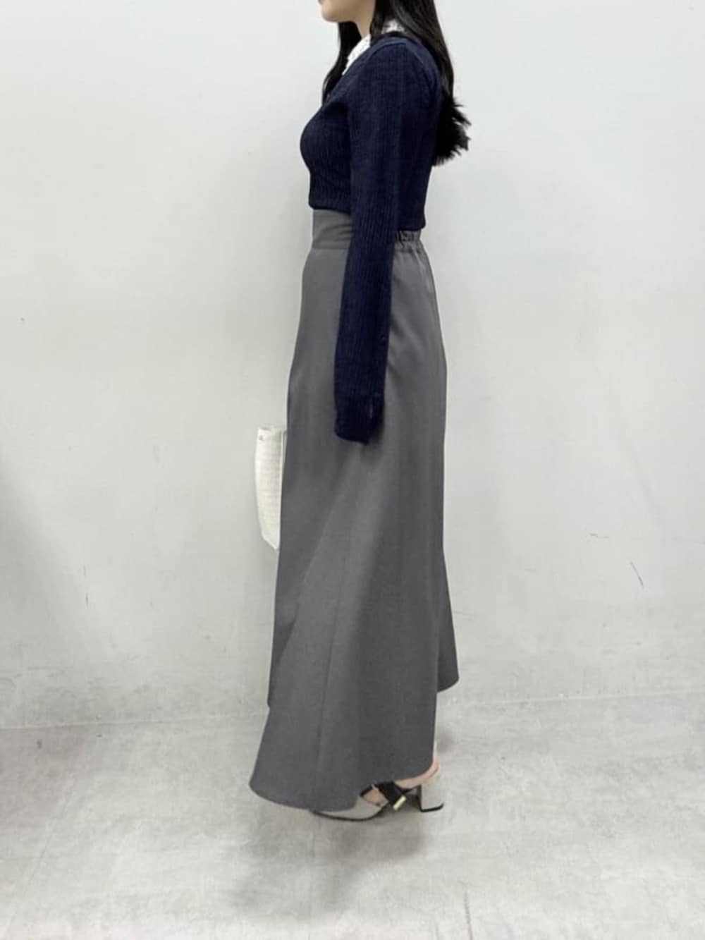 ホワイト系のハンドバッグ、グレー系のサンダル、グレー系のスカートを着用したレディースの春コーディネートの2枚目の写真