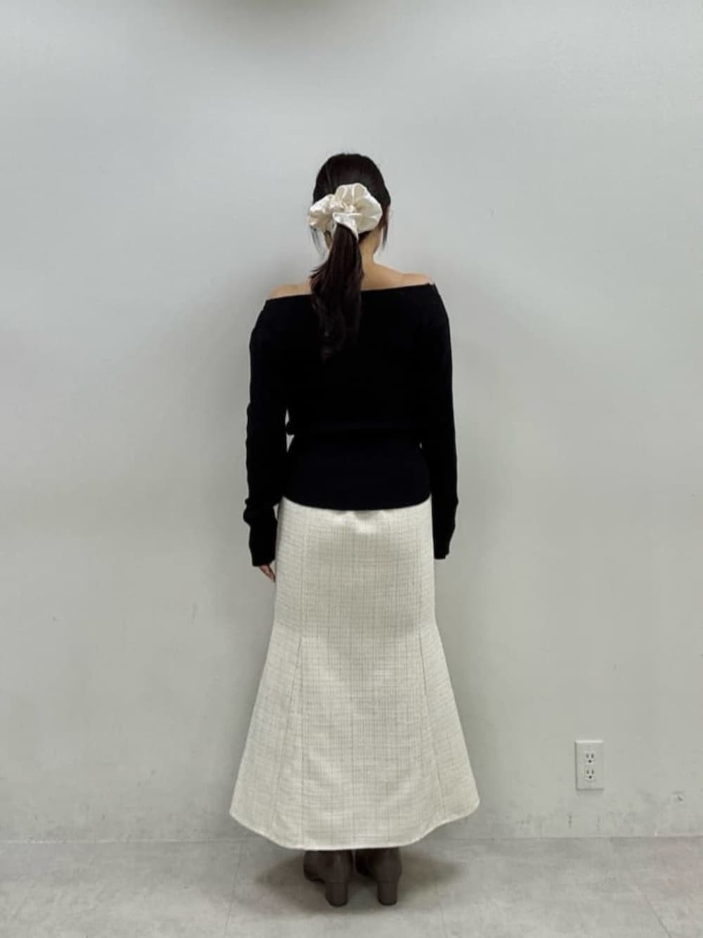 ホワイト系のスカート、ブラック系のニット/セーターを着用したレディースの秋コーディネートの3枚目の写真