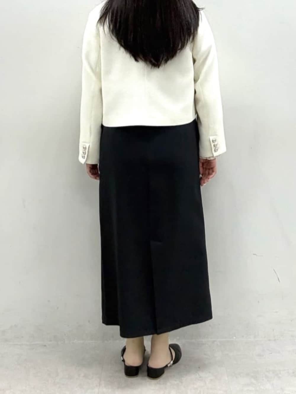 ブラック系のスカート、ホワイト系のノーカラージャケット、ホワイト系のシャツ/ブラウスを着用したレディースの冬コーディネートの3枚目の写真