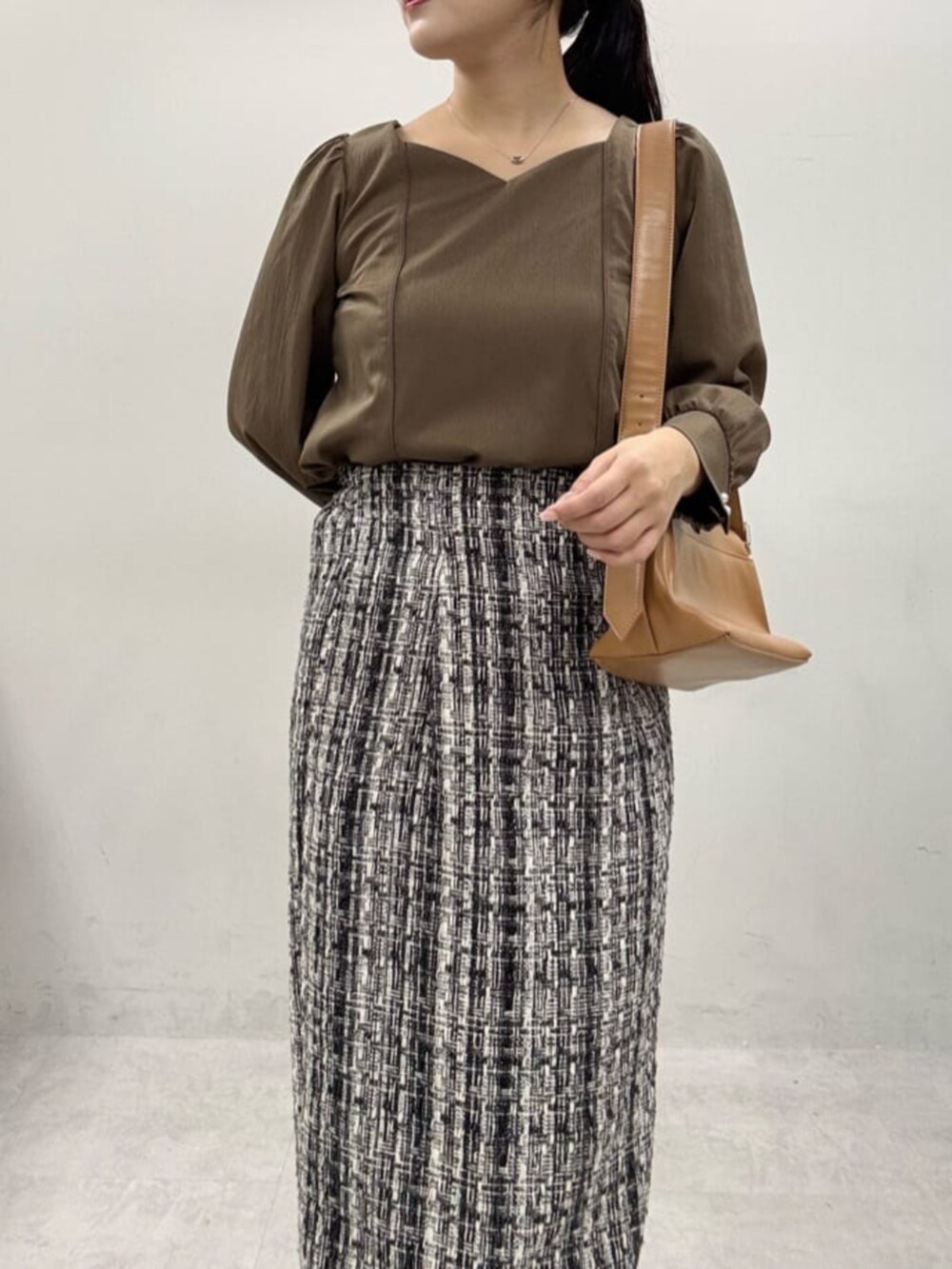 グレー系のスカート、ブラック系のブーツ、ブラウン系のシャツ/ブラウスを着用したレディースの秋コーディネートの4枚目の写真