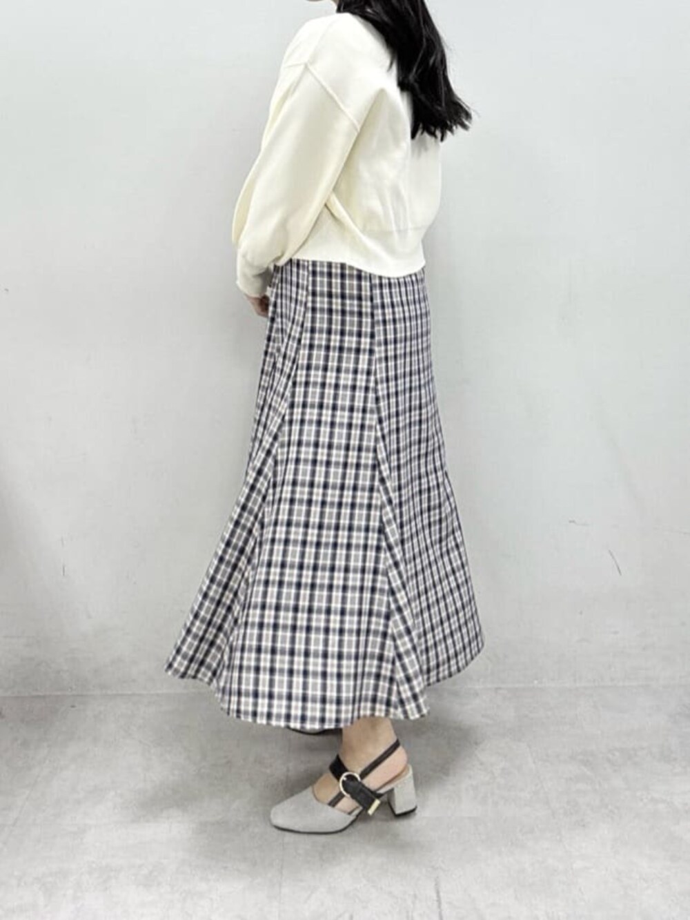 グレー系のサンダル、ブルー系のワンピース、ホワイト系のカーディガン/ボレロを着用したレディースの冬コーディネートの3枚目の写真