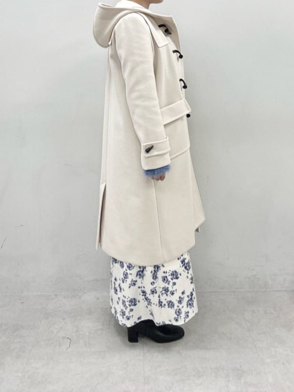 ブルー系のニット/セーターを着用したレディースの冬コーディネートの2枚目の写真