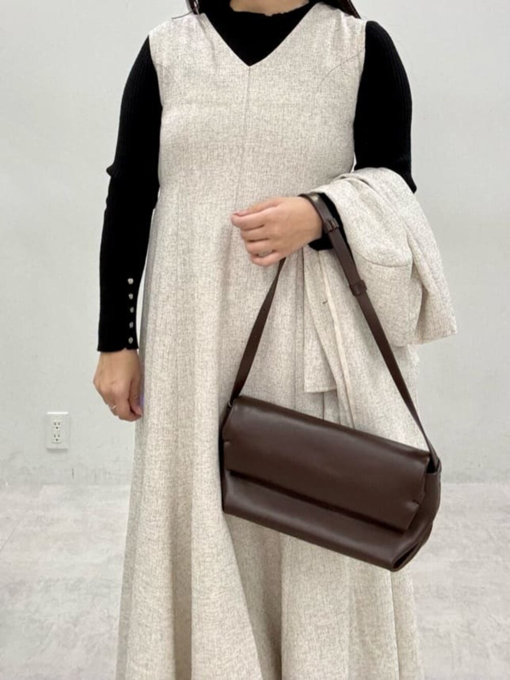 ブラック系のニット/セーター、ホワイト系のワンピースを着用したレディースの秋コーディネートの4枚目の写真