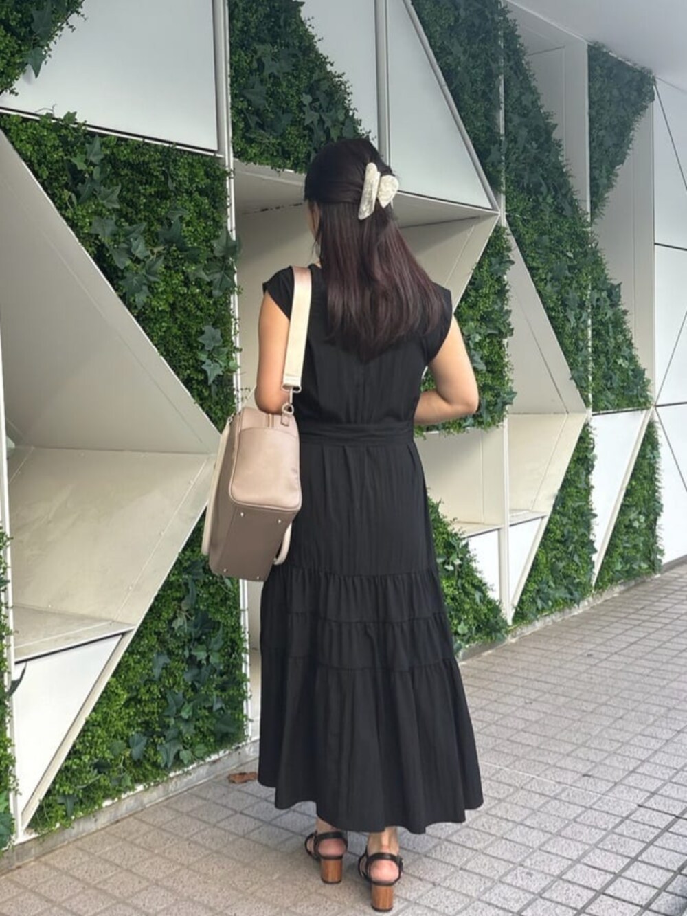 ベージュ系のボストンバッグ、ブラック系のワンピースを着用したレディースの秋コーディネートの4枚目の写真