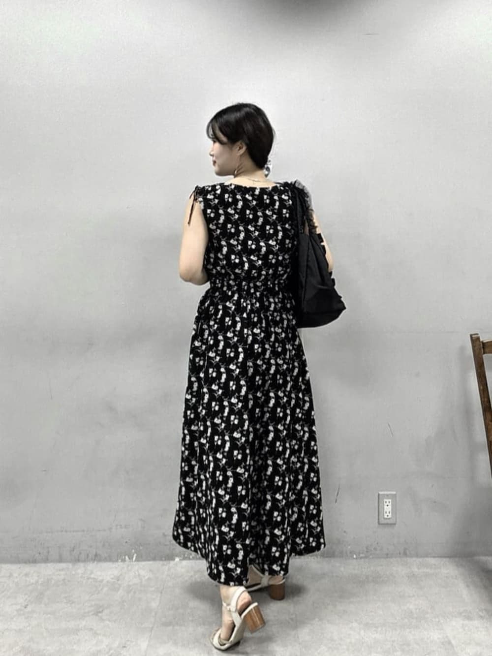 ブラック系のワンピース、ホワイト系のカーディガン/ボレロ、ブラック系のトートバッグを着用したレディースの夏コーディネートの4枚目の写真