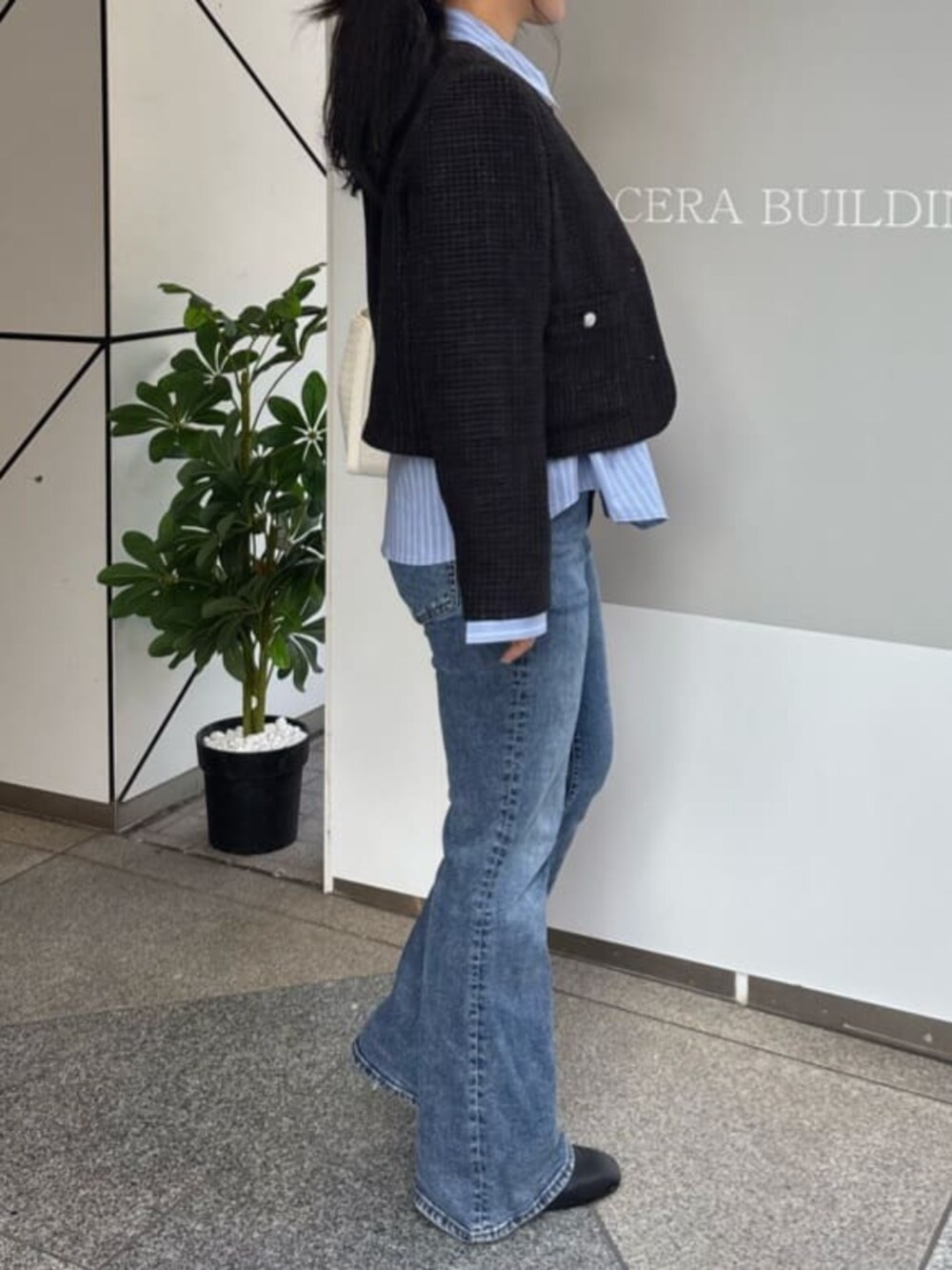 ブルー系のシャツ/ブラウス、ホワイト系のハンドバッグを着用したレディースの冬コーディネートの2枚目の写真