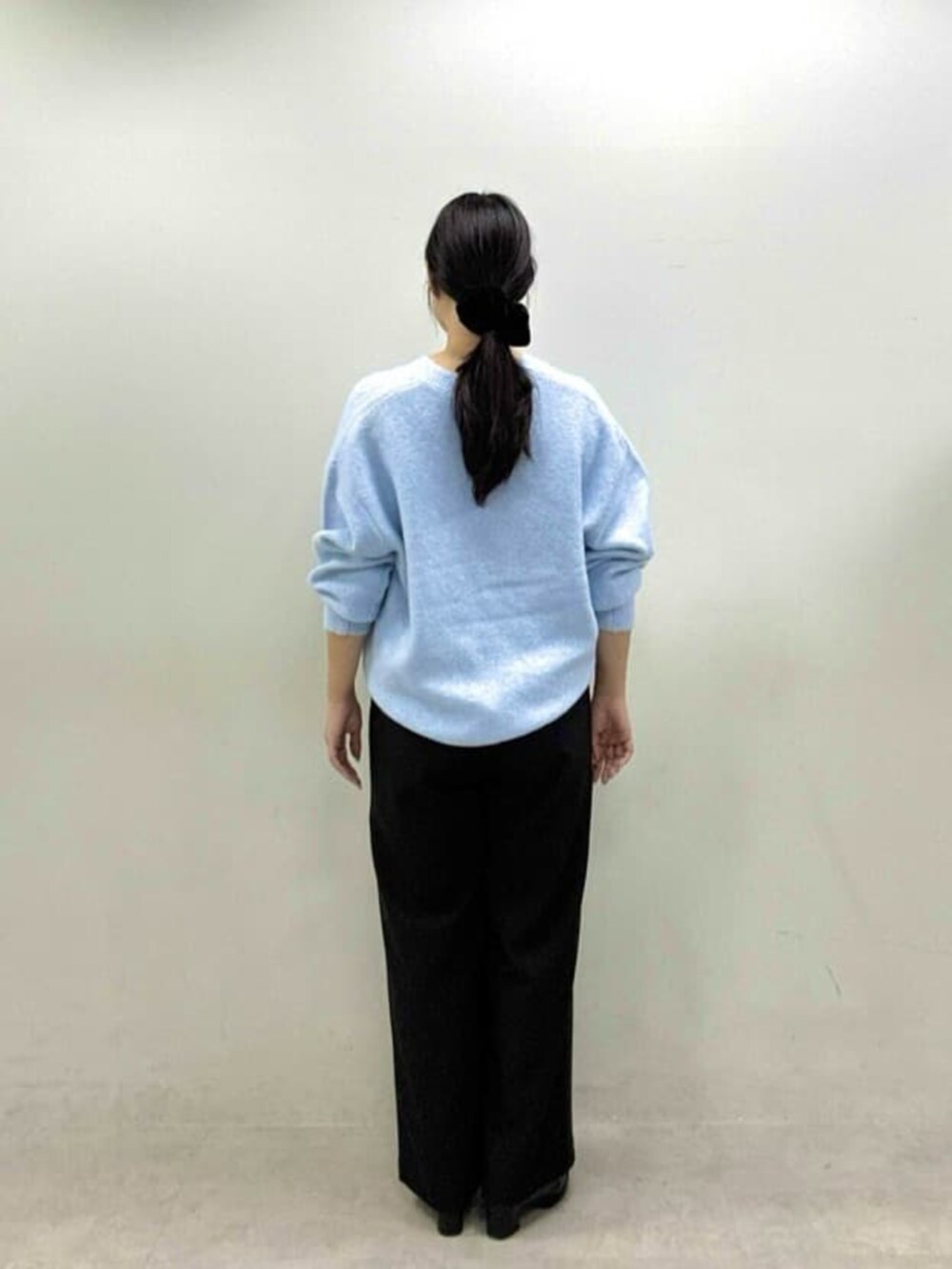 ブルー系のニット/セーター、ブラック系のその他パンツを着用したレディースの秋コーディネートの6枚目の写真