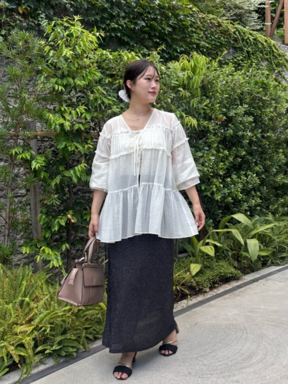 ブラック系のスカート、ホワイト系のシャツ/ブラウスを着用したレディースの夏コーディネートの2枚目の写真