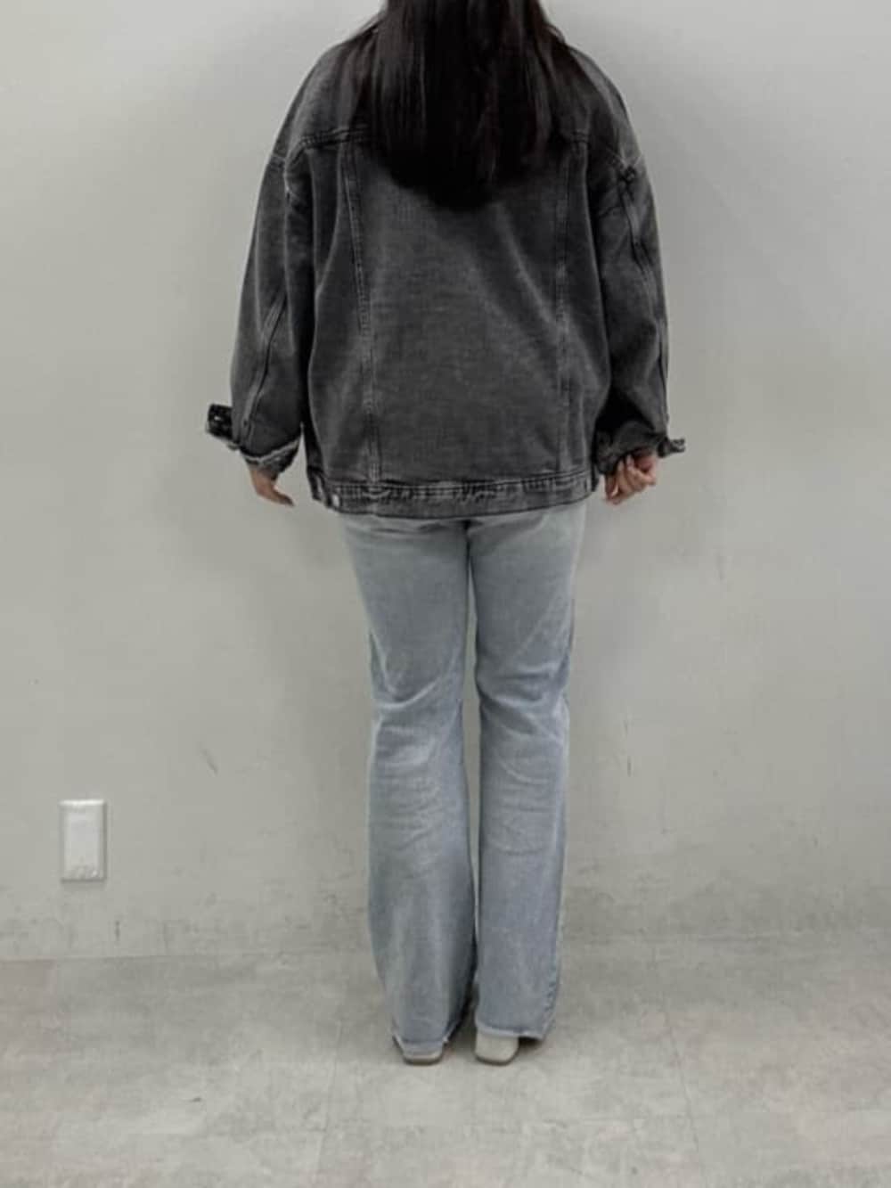 ブルー系のデニムパンツ、ホワイト系のサンダル、イエロー系のニット/セーターを着用したレディースの冬コーディネートの3枚目の写真