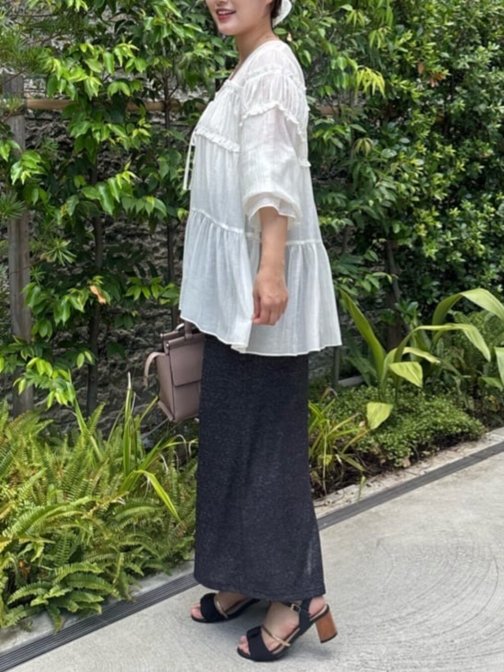 ブラック系のスカート、ホワイト系のシャツ/ブラウスを着用したレディースの夏コーディネートの4枚目の写真