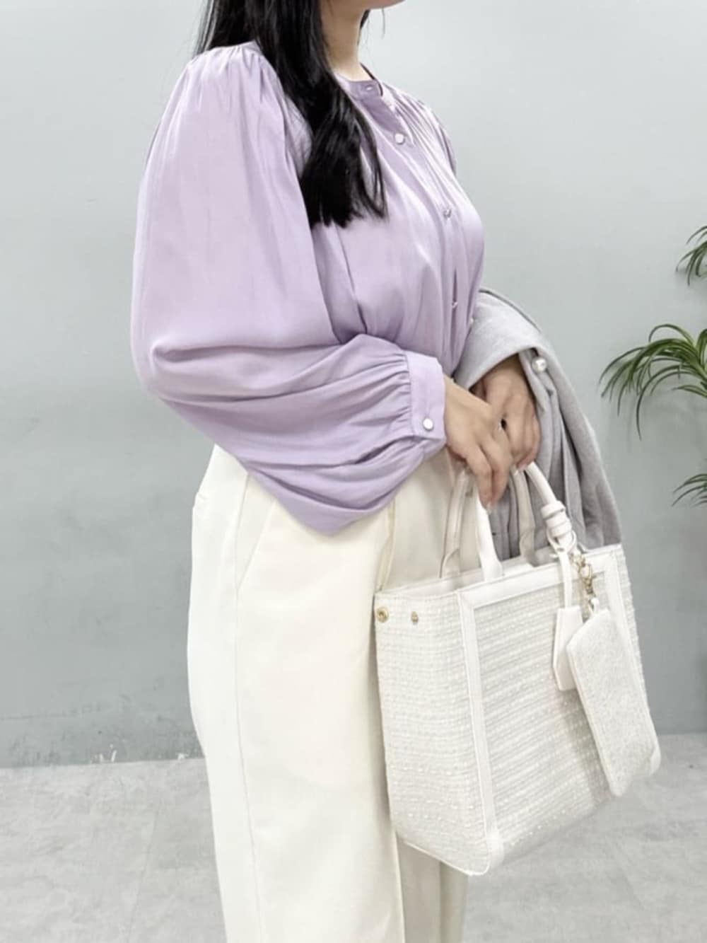 ホワイト系のハンドバッグ、パープル系のシャツ/ブラウス、ホワイト系のスラックスを着用したレディースの冬コーディネートの4枚目の写真