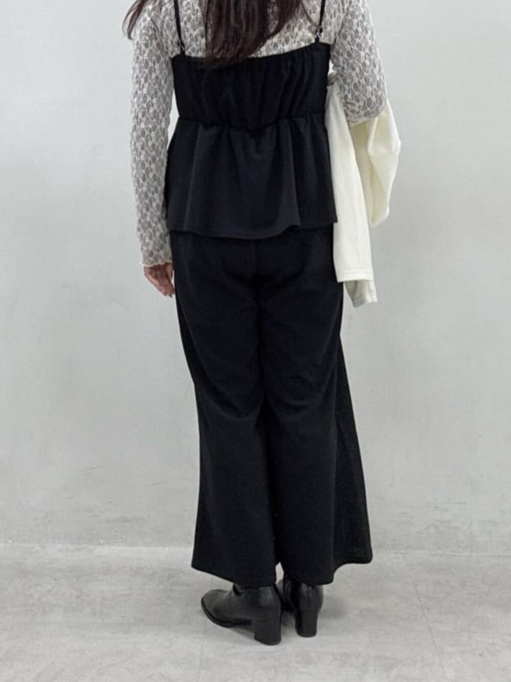 グレー系のTシャツ/カットソー、ブラック系のつなぎ/オールインワン、ホワイト系のカーディガン/ボレロを着用したレディースの冬コーディネートの4枚目の写真