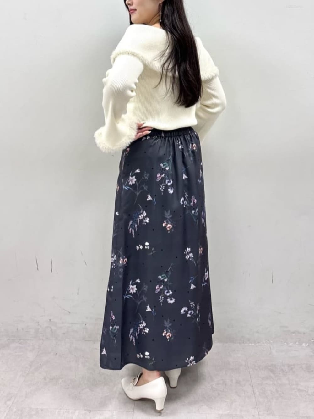 ベージュ系のニット/セーター、グレー系のスカートを着用したレディースの夏コーディネートの3枚目の写真