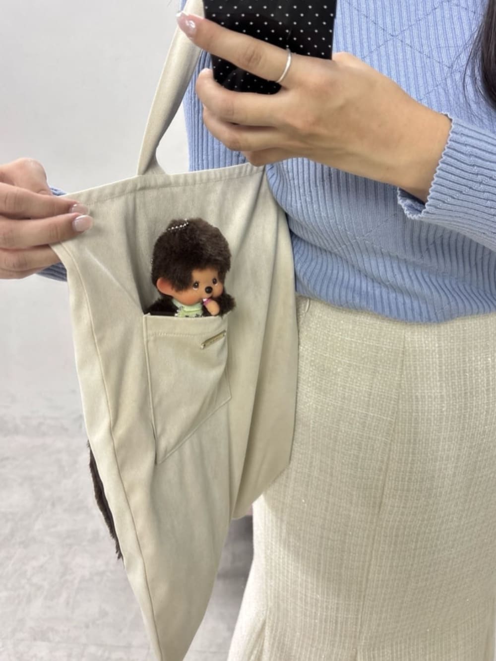 ホワイト系のスカート、ホワイト系のトートバッグ、ブルー系のニット/セーターを着用したレディースの冬コーディネートの4枚目の写真