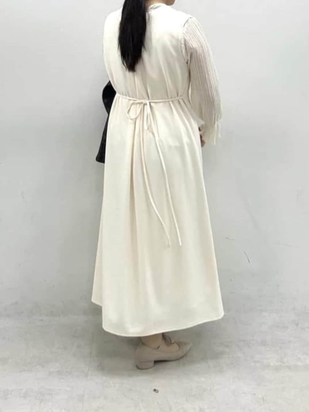 ブラック系のノーカラージャケット、ホワイト系のワンピースを着用したレディースの冬コーディネートの4枚目の写真