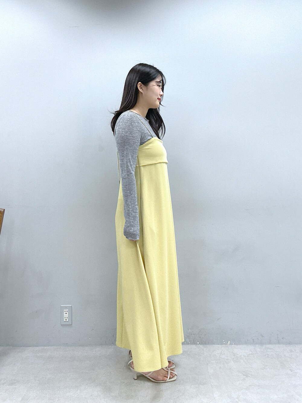イエロー系のワンピース、グレー系のTシャツ/カットソーを着用したレディースの春コーディネートの2枚目の写真