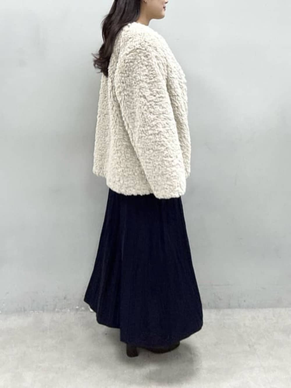 ブルー系のワンピース、ベージュ系のノーカラーコートを着用したレディースの秋コーディネートの2枚目の写真