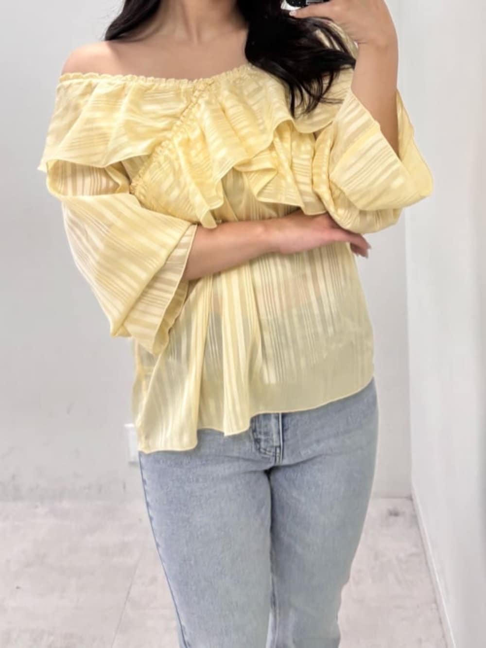 イエロー系のシャツ/ブラウス、ブルー系のデニムパンツを着用したレディースの冬コーディネートの8枚目の写真