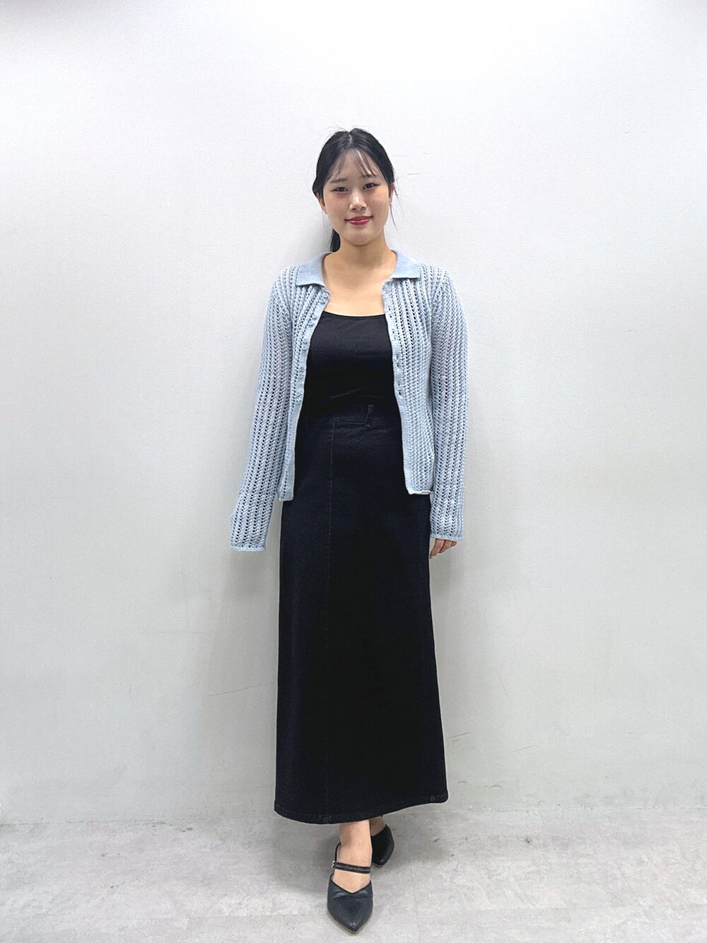 ブラック系のスカート、ブルー系のカーディガン/ボレロ、ブラウン系のショルダーバッグを着用したレディースの冬コーディネートの3枚目の写真