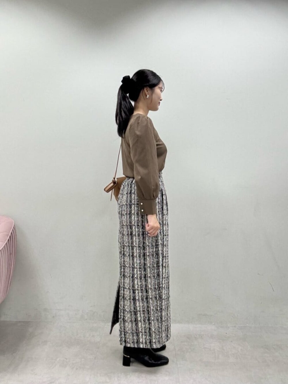 グレー系のスカート、ブラック系のブーツ、ブラウン系のシャツ/ブラウスを着用したレディースの秋コーディネートの2枚目の写真