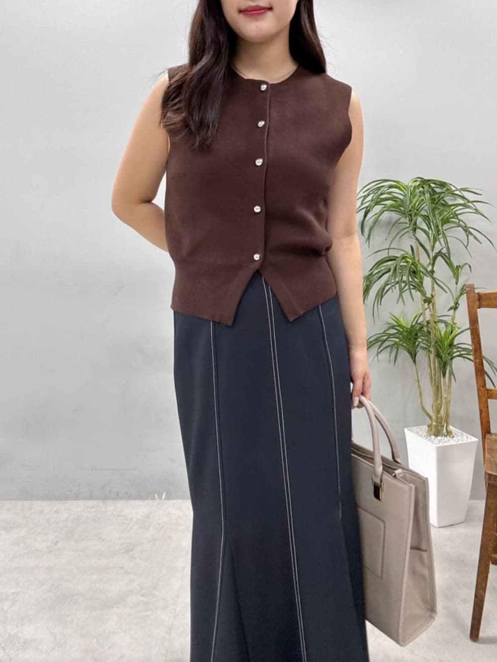 ブルー系のスカート、ブラウン系のニット/セーターを着用したレディースの夏コーディネートの2枚目の写真