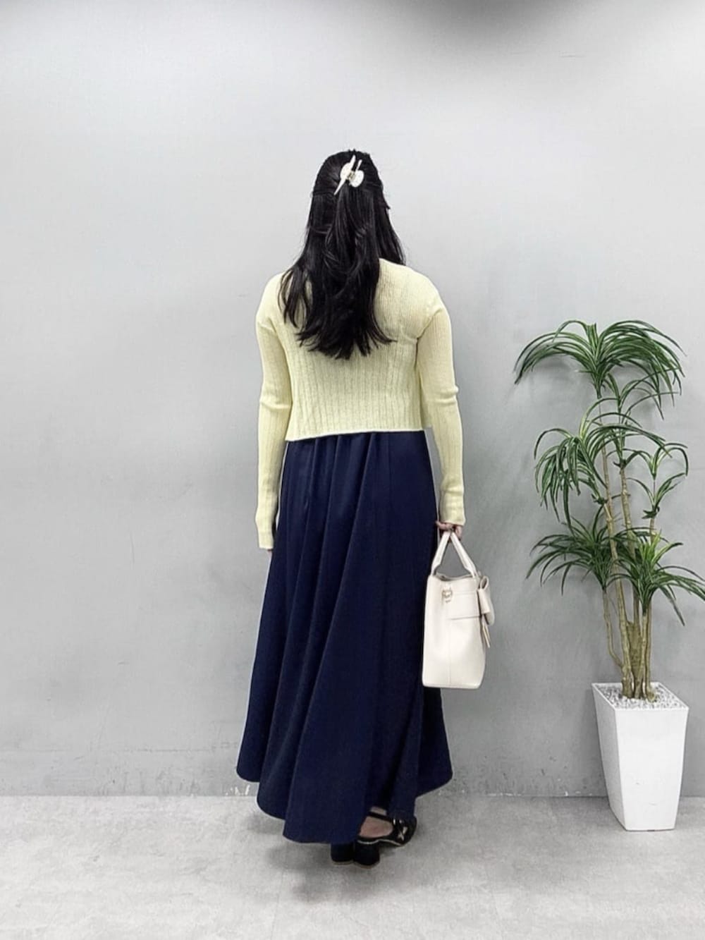 イエロー系のカーディガン/ボレロ、ブルー系のワンピースを着用したレディースの春コーディネートの3枚目の写真