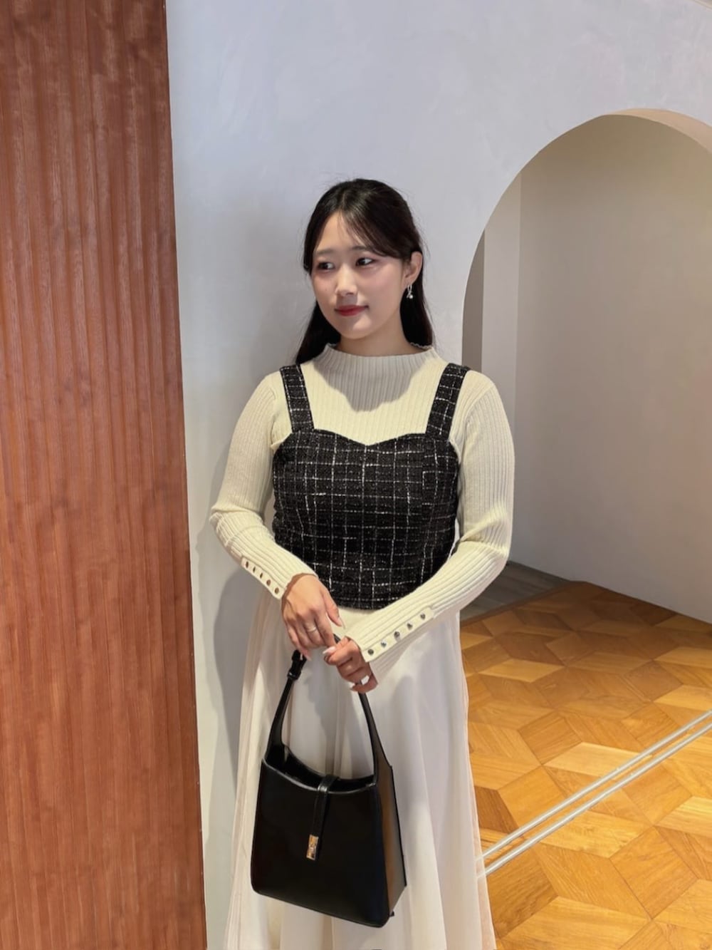 ホワイト系のスカート、ブラック系のシャツ/ブラウス、ホワイト系のニット/セーターを着用したレディースの秋コーディネートの3枚目の写真