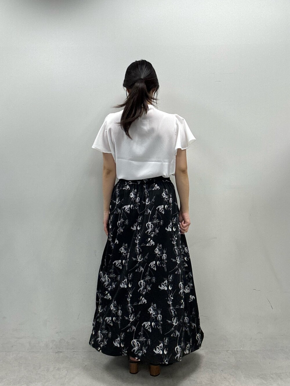 ブラック系のスカート、ホワイト系のシャツ/ブラウスを着用したレディースの春コーディネートの3枚目の写真