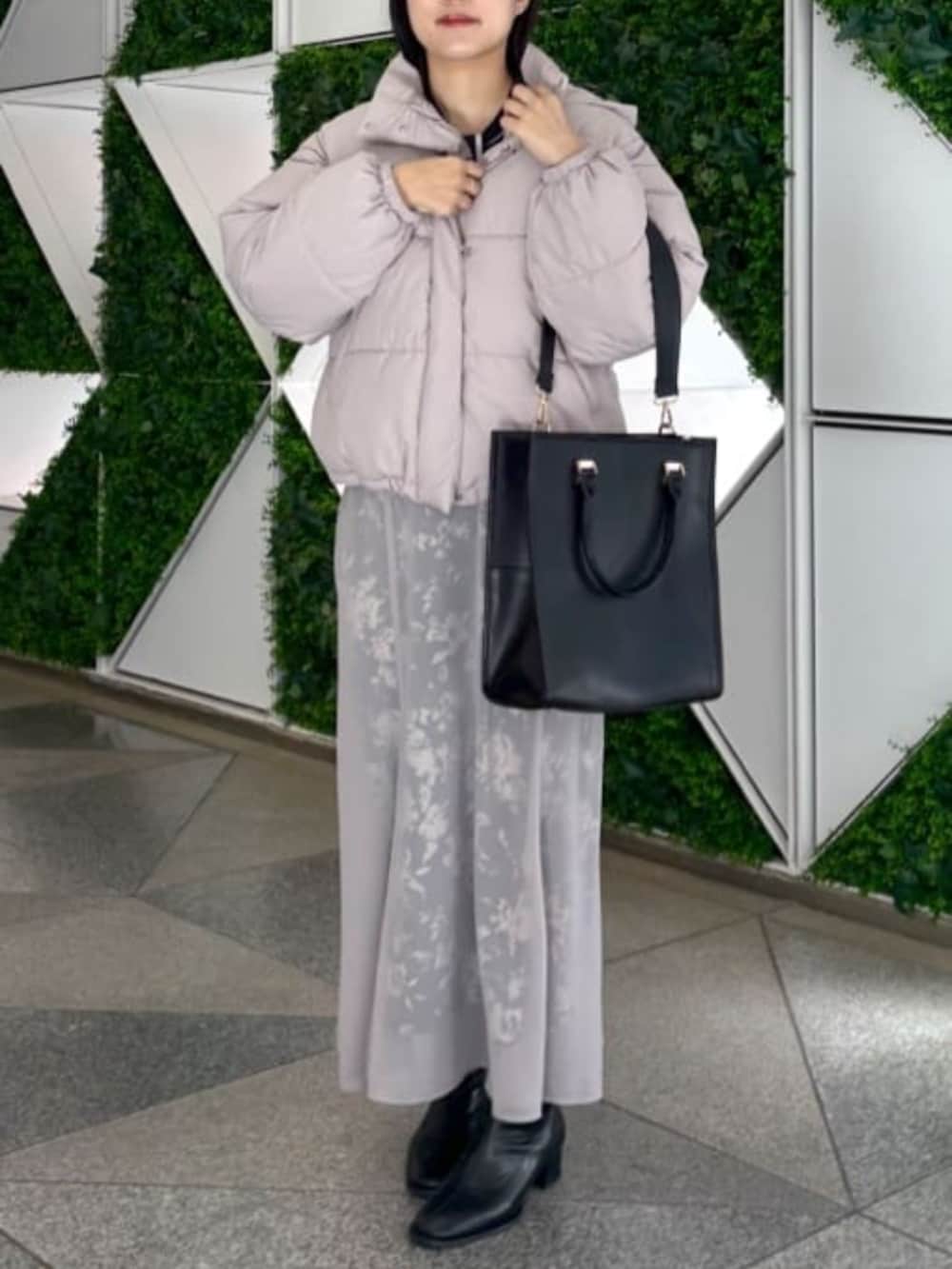 ブラック系のスカート、ベージュ系のダウンジャケット/コート、ブルー系のシャツ/ブラウスを着用したレディースの秋コーディネートの6枚目の写真