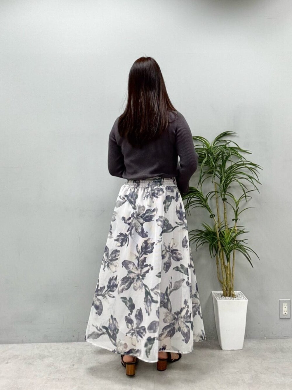 グレー系のニット/セーター、ホワイト系のスカートを着用したレディースの夏コーディネートの3枚目の写真